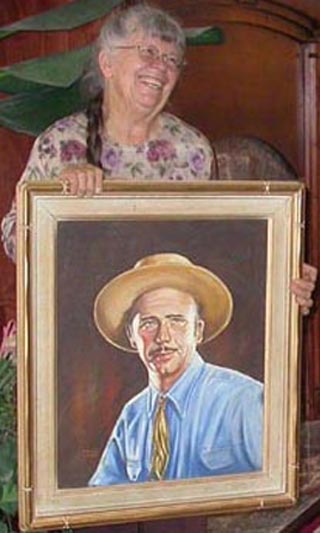 Kathi Hilton with a portrait of her dad, artist John W. Hilton